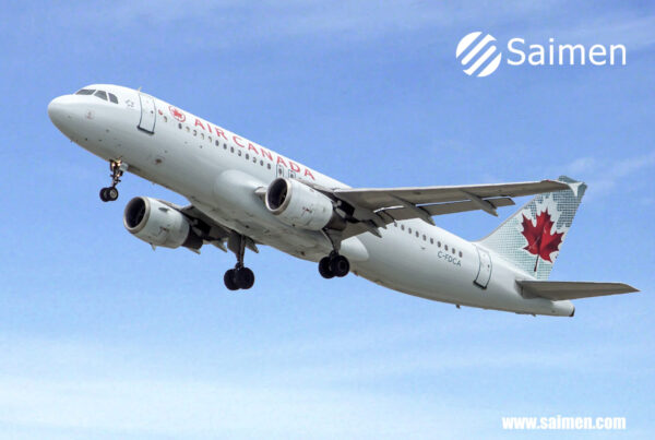 Air Canada airplane with the Canadian flag on its tail, taking off against a clear sky